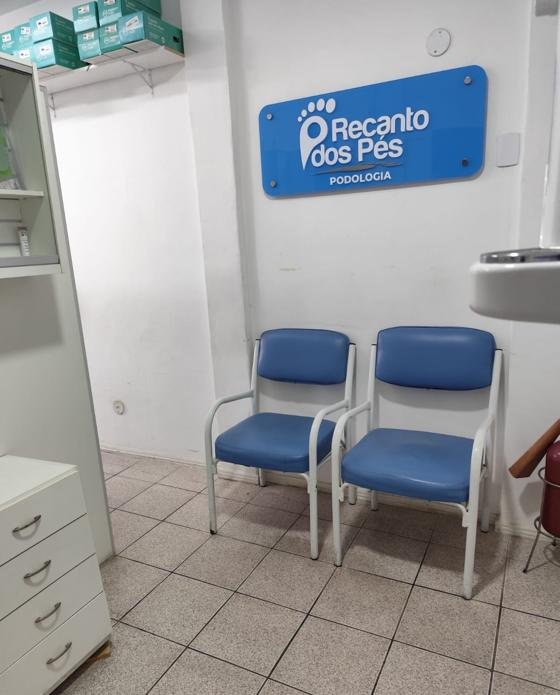 Sala de espera com cadeiras azuis e placa da Recanto dos Pés